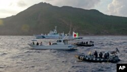 日本海上保安厅船只与一艘悬挂日本国旗的由日本活动人士驾驶的渔船在尖阁诸岛附近(中国称到钓鱼岛)。(资料照:2013年8月18日))