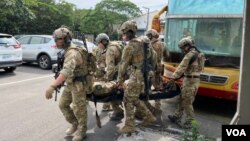 民间军警专长训练公司极光训练于6月18日模拟两岸城市激战,学员学习如何在战场搬运伤员。(美国之音特约记者金谷摄)