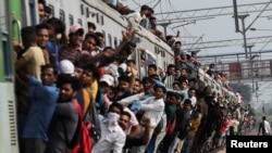 资料照片:一列挤满人群的火车在新冠疫情期间驶离印度加济拉巴德的车站。(2021年9月21日)