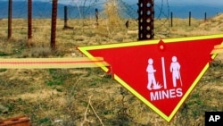 资料照:巴格拉姆空军基地雷场旁悬挂着国际地雷警告标志。(2002年3月22日)