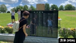 一位悼念者在刻有176位逃港罹难知青名字的碑前。(美国之音记者方冰拍摄,2022年6月15日)