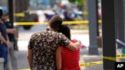 一对新婚夫妇望着伊利诺伊州芝加哥附近海兰帕克枪击惨案的现场。(2022年7月5日)