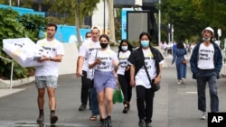 资料照片：人们在墨尔本举行的澳大利亚网球公开赛决赛前穿着“彭帅在哪里？"T恤衫。(2022年1月29日)