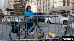 自行车骑士凯特·安斯泰特在纽约市西街自行车道上警察设置的路障旁的临时纪念地点擦拭眼泪。(2017年11月1日)