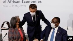 资料照:2021年5月18日,在巴黎举行的非洲经济体融资峰会上,法国总统马克龙(中)向埃塞俄比亚总统萨赫勒-沃克·祖德(左)和塞内加尔总统麦基·萨勒致敬。