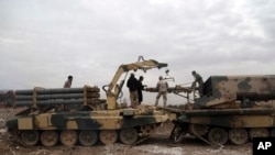 在打击伊斯兰国激进分子,以夺回摩苏尔大学控制权的战斗中,伊拉克军士兵把火箭装入一个多管发射器中。(2017年1月13日)