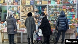 俄罗斯西伯利亚城市鄂木斯克的顾客在一个售货亭外排队等候购买食品。 (2024年11月29日)
