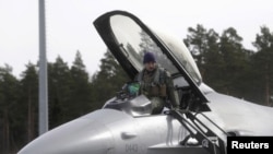 资料照片:2015年3月26日,在阿马里空军基地,美国空军第510战斗机中队一名飞行员正从F-16战斗机上下来。(路透社照片)