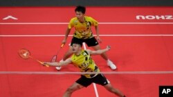 Pebulu tangkis Taiwan Wang Chi-lin (di belakang) dan Lee Yang sedang berlaga melawan Kim Astrup dan Anders Skaarup Rasmussen dari Denmark dalam final turnamen BFW di Hangzhou, Zhejiang, Kamis, 12 Desember 2024. (Foto: Andy Wong/AP Photo)