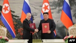 俄罗斯总统普京与朝鲜领导人金正恩在平壤举行的签字仪式上合影。(2024年6月19日)