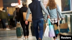 在美国宾夕法尼亚州普鲁士国王购物中心,顾客们提着购物袋(2018年12月8日)。