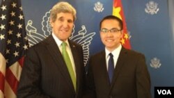 资料照:原任腾讯财经频道编导的张贾龙(右)会见前美国国务卿约翰·克里。(维权网图片)