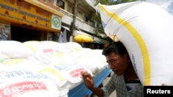 一名柬埔寨男子在金边的一辆卡车旁扛起一袋大米。(2017年7月12日)