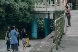 饰演秀英阿嬷的陈淑芳(右)向穿着青蓝色大衣的死去丈夫的情人(丁宁饰)喊了一声:“蔡小姐!”(威视电影授权提供)