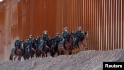 资料照片:美国边境巡逻队在埃尔森特罗(El Centro)区美墨边境围墙下的的一支骑警分队(2018年10月26日)