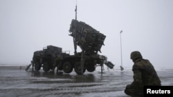 Quân đội Đức bên cạnh một giàn phi đạn Patriot trong một buổi diễn tập truyền thông owr Warbelow, 18/12/2012.