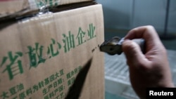 2018年7月4日,在中国山东省曲阜市,在粮油工业和进出口公司的工厂,瓶装大豆油的盒子上印着“放心油企业”“原料产国:美国”。