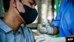 2023年12月19日,一名卫生工作者在雅加达省卫生办公室为一名男子接种 Covid-19 疫苗。(法新社照片)