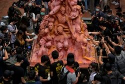 香港大学的学生在清理为悼念六四死难者而树立的“国殇之柱”。（2021年6月4日）