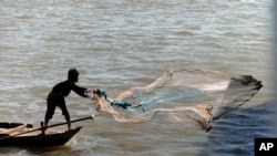 一位渔民在金边的湄公河上撒网。(资料照)