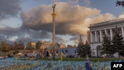 资料照片:在基辅独立广场,穿着军服的行人走过纪念阵亡乌克兰军人的旗帜。(2023年10月23日)