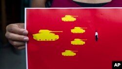 一名藏族学生在印度达兰萨拉手持八九六四坦克人的图画纪念六四事件31周年。(2020年6月4日)