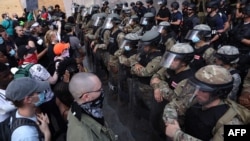 Demonstrators stand in front of D.C. National Guard and other law law enforcement officers during a peaceful protest against police brutality and the death of George Floyd, on June 3, 2020 in Washington, D.C.