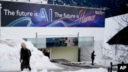 Spanduk iklan dengan slogan tentang AI di sebuah gedung di Davos Promenade, di samping Forum Ekonomi Dunia di Davos, Swiss, 18 Januari 2024. PadaPilpres AS 2024, kedua kandidat, Joe Biden dan Donald Trump menggunakan AI untuk menarik pemilih. (Foto: AP)