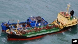 日本防务省2018年2月16日发布的照片显示挂有朝鲜旗帜的油轮在东中国海海域进行海上交易。日本方面怀疑联合国对朝制裁遭破坏。