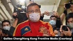 港媒《立场新闻》副采访主任陈朗升在离开办公室时向香港媒体招手。(2021年12月29日)