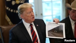 美国总统特朗普在华盛顿白宫的内阁会议室,手举一张边境屏障的设计图片。(2019年1月11日)