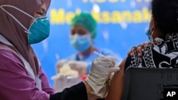A health worker gives a jab of the Sinovac COVID-19 vaccine to a woman during a vaccination campaign at the Adam Malik Hospital in Medan, North Sumatra, Indonesia, June 30, 2021.