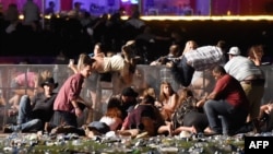 在明显的枪声出现之后,人们试图逃离内华达州拉斯维加斯的户外乡村音乐演唱会现场(2017年10月1日)