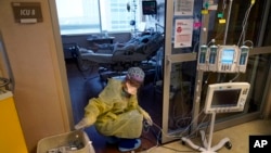 洛杉矶一所医疗中心的一名护士在为重症监护室里的新冠患者整理医疗仪器的电线。(2021年8月17日)