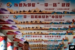 2018年6月29日,在北京举行的一次活动中展示的中国国家主席习近平的“中国梦”和“一带一路”政策上网宣传牌,一名男子站在下面。