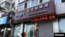 行人路过凯文·高夫妇在丹东经营的咖啡馆(2014年8月5日)