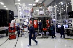 SpaceX employees work on the Crew Dragon spacecraft that will astronauts to and from the International Space Station, from American soil, as part of the agency's commercial crew Program, in Hawthorne, Calif., Oct. 10, 2019.