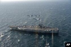 美日战机飞越美国海军里根号航空母舰。(2017年11月10日)