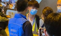 16岁中学生记者Perry7月19日下午在元朗西铁站采访7-21袭击事件一周年纪念活动,被警方传媒联络队人员截查 (美国之音/汤惠芸)