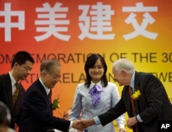 资料照:美国前总统卡特(右)在北京出席纪念美中建交30周年的研讨会上与时任中国副总理钱其琛(左二)握手。( 2009年1月12日)