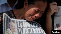 2016年10月14日,在泰国国王普密蓬遗体从他去世的医院移送到曼谷大皇宫的路上,一个女子在路边哭泣。