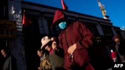 在中国西藏自治区首府拉萨,一名僧侣走在大昭寺外诵经。(2016年9月10日)