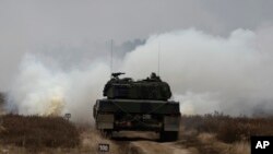 资料照片:乌克兰与波兰军人在波兰希维托舒夫一处军事基地兼试验场训练驾驶豹2坦克。(2023年2月13日)