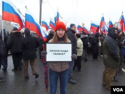 3月1日莫斯科悼念反对派领袖涅姆佐夫的游行中，一名参加者手举标语：（官方）宣传在杀人。（美国之音 白桦拍摄））