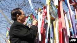 Ông Shigeo Iizuka, 72 tuổi, người anh em của một công dân Nhật Bản được cho là bị Bắc Triều Tiên bắt cóc, buộc dải ruy băng lên hàng rào thép gai ở khu phi quân sự phân chia hai miền Triều Tiên.