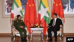 资料照片:2020年1月18日,缅甸敏昂莱大将(左)在内比都会见中国国家主席习近平时交谈。