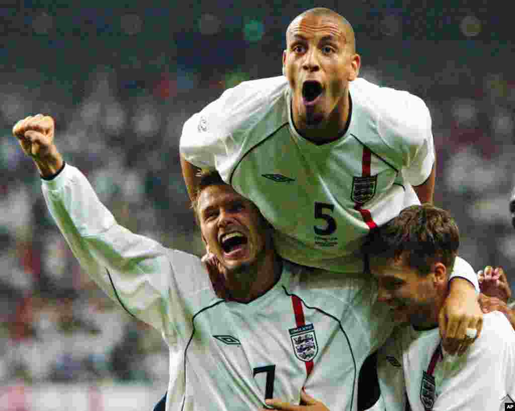 Beckham (trái), Rio Ferdinand (trên cùng) và Michael Owen ăn mừng tuyển Anh ghi bàn thắng thứ 2 vào lưới Đan Mạch tại vòng chung kết World Cup ở Niigata, Nhật, ngày 15 tháng 6, 2002.