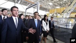 法国总理瓦尔斯(左)陪同中国总理李克强参观图卢兹附近的空客A360组装厂(2015年7月2日)