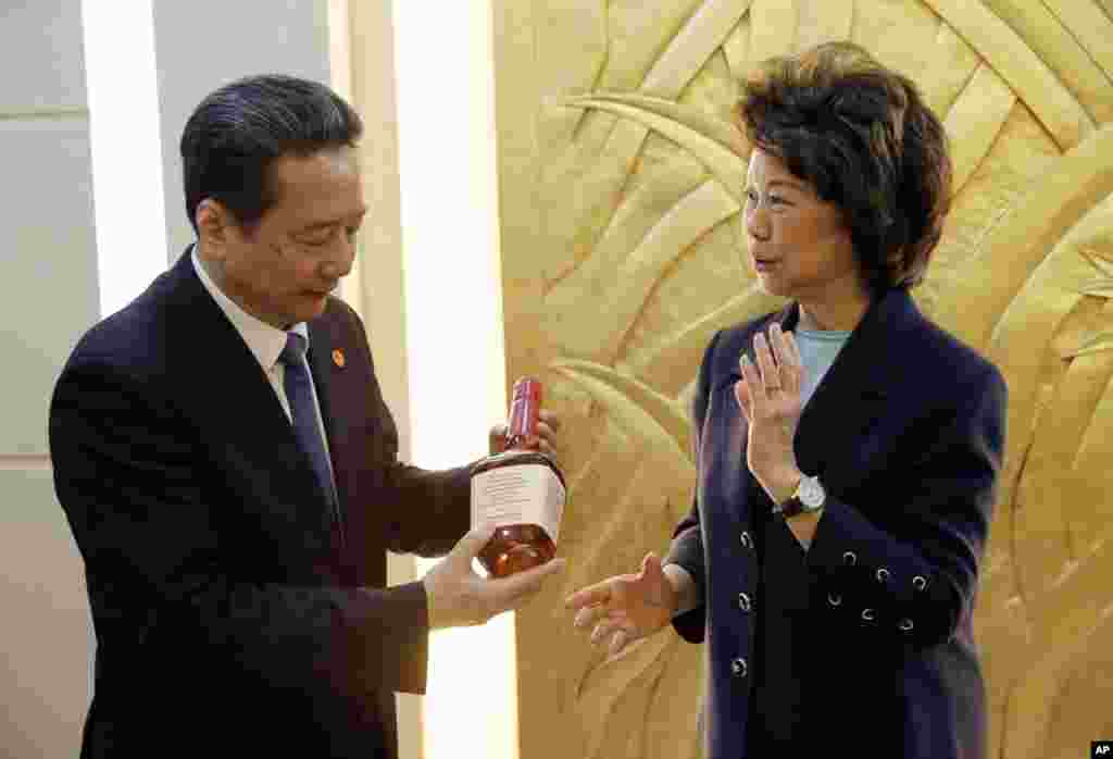 2018年4月27日,在中国交通部签署仪式后,中国交通部长李小鹏手持一瓶威士忌酒,这是美国运输部长赵小兰给他的礼物。