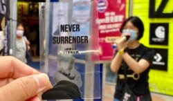 反对当局收紧查册安排的工会街站，向市民派发印有中国异见艺术家艾未未《透视研究》的透明卡片，呼吁市民”揸紧宗旨，千祈唔好惯”，意即“站稳态度，不要麻木习惯” (美国之音/汤惠芸)